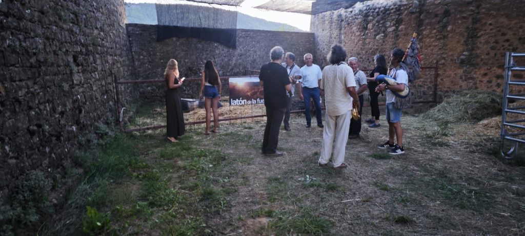 Visitantes en el corral del Castillo de Aínsa al caer la tarde, con música de gaita